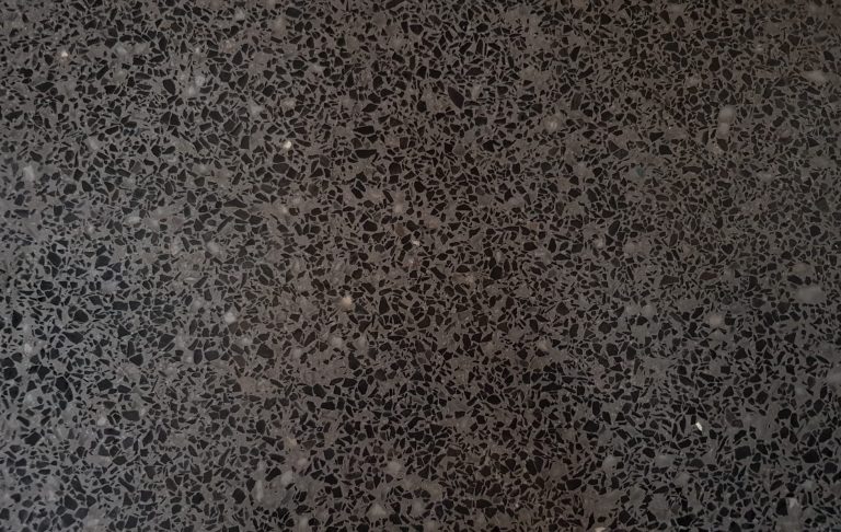 Dunkler Terrazzo mit schwarzer grob Körnung in grauem Bindemittel und Spiegelbruch